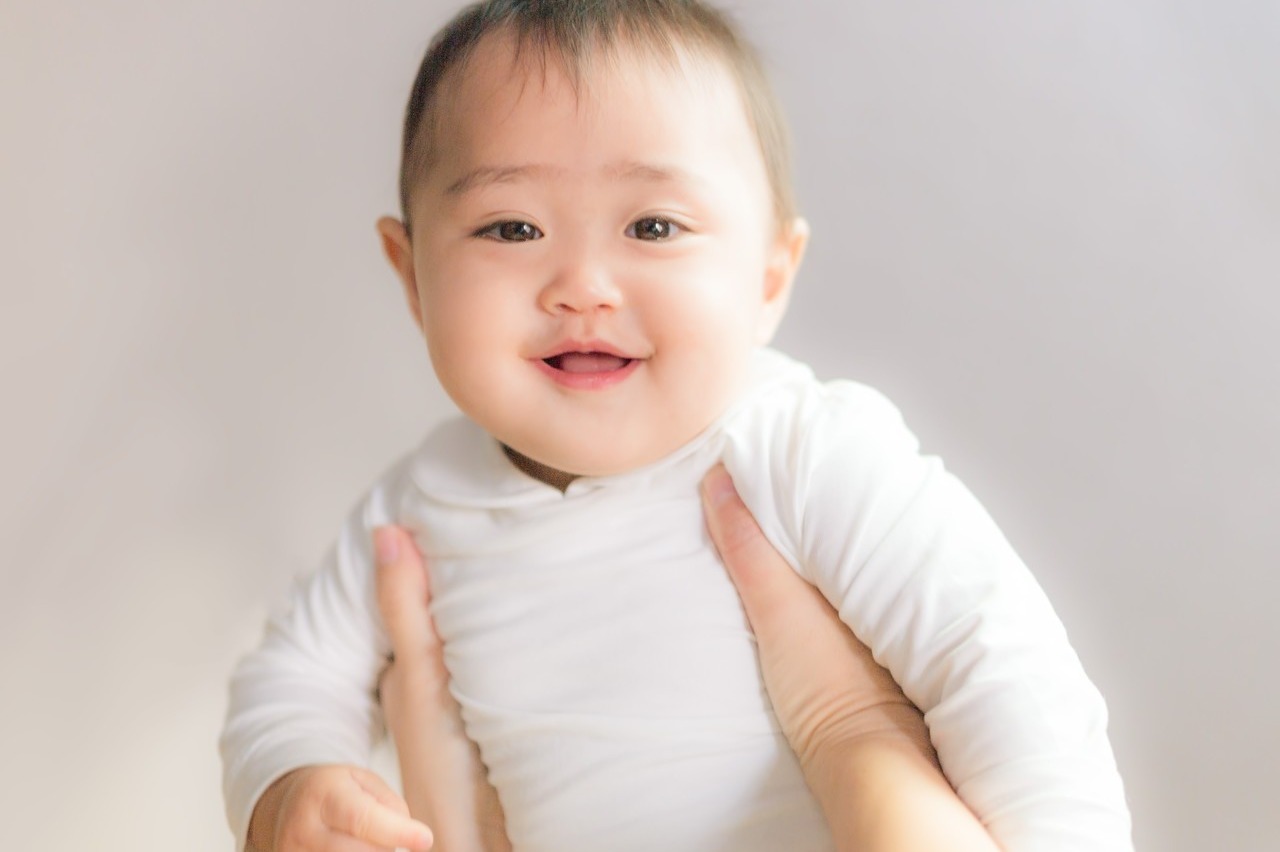 抱きかかえられる赤ん坊