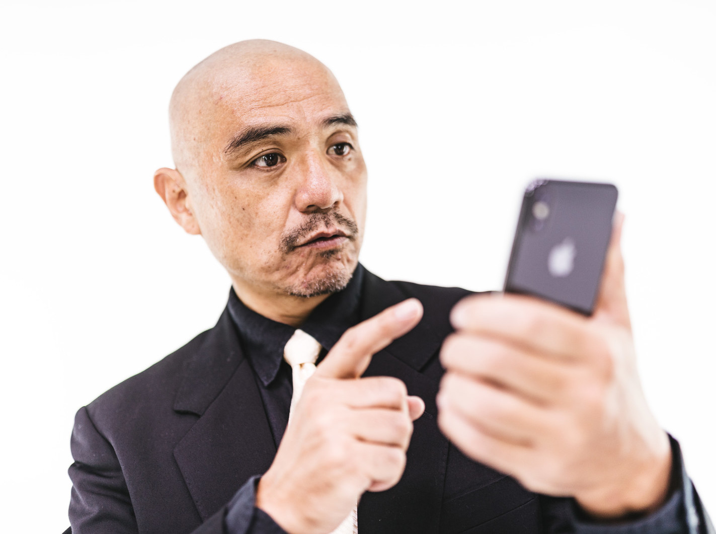 スマホを見ながら何かに気づくスキンヘッド男性.jpg
