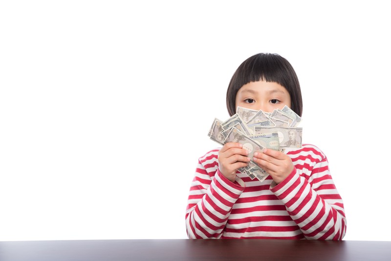 バイトで稼いだお金をもつ女の子の画像