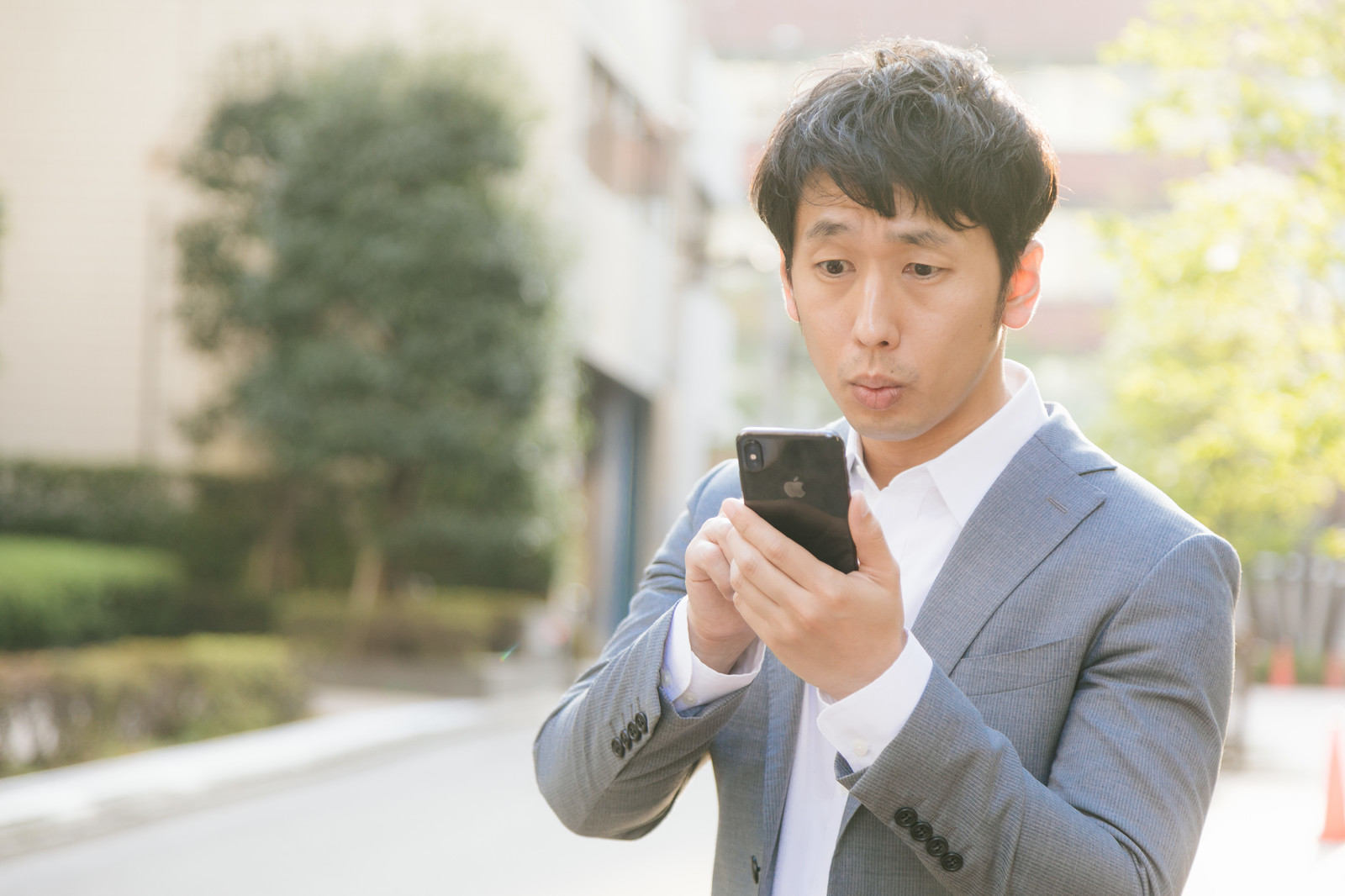 困り顔でスマホを触る画像.jpg