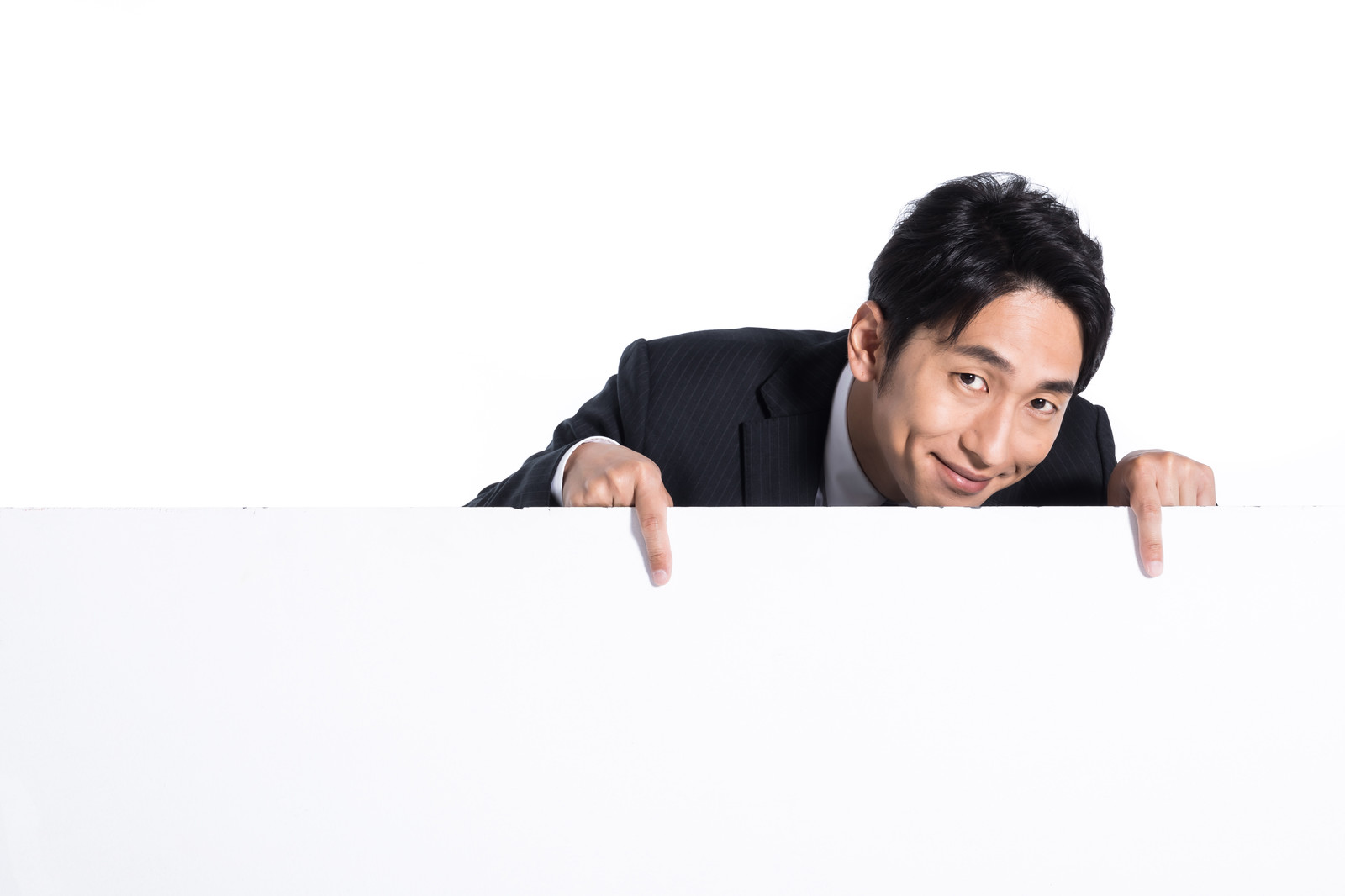 下を指差すスーツの男性