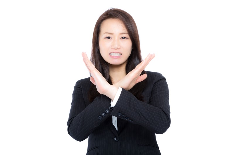 バツポーズをする女性の画像