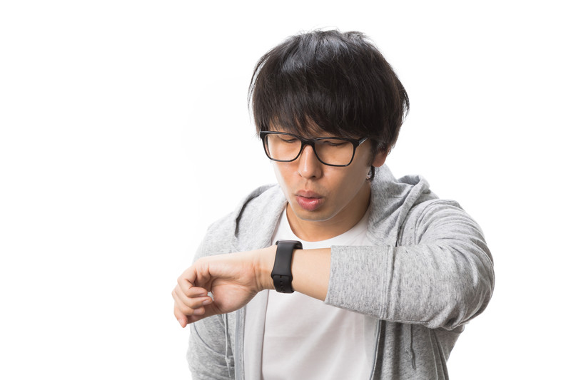 時間を気にする男性の画像