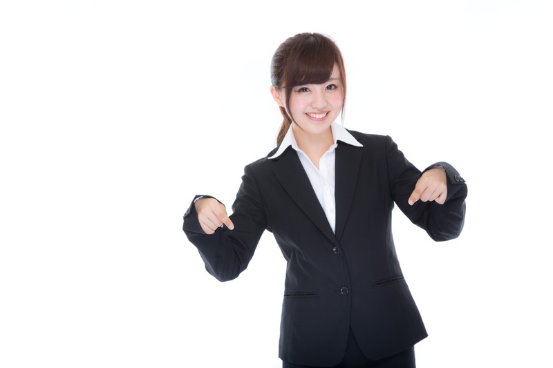 下を指差す女性の画像