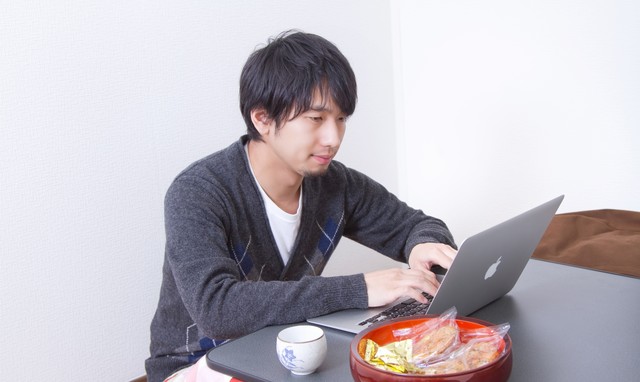 こたつの上でパソコンを触る男性.jpg